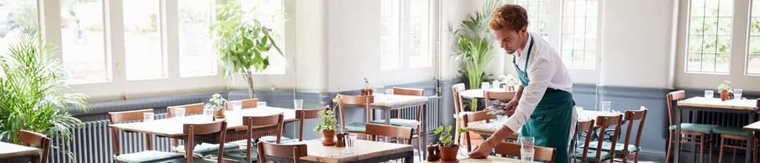 A server setting up a dinner table at a restaurant