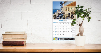 Promotional Calendar on a desk with books and a plant, against a white brick wall.