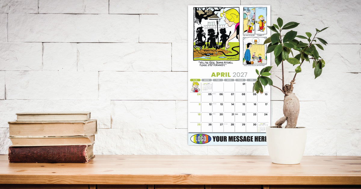 Promotional Calendar on a wooden surface with books and a plant, against a white brick wall.