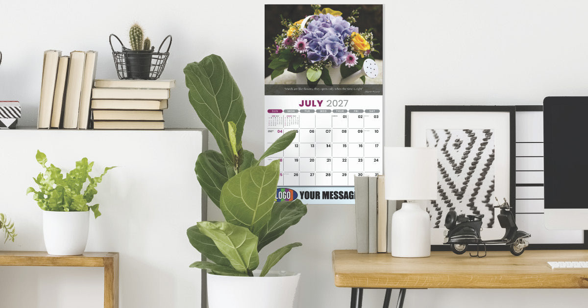 Home office setup with plants, books, a calendar, and decorative items on a white wall.