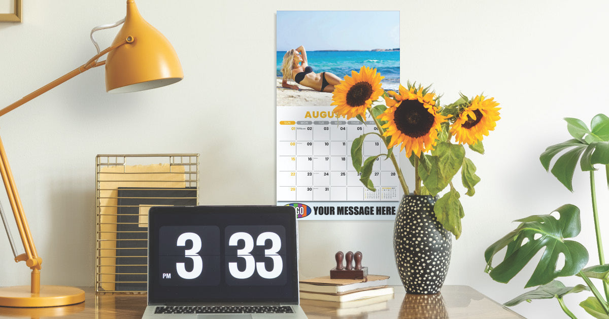 Branded business promotional calendar | 2027 Swimsuits on wall with desk, sunflower, laptop and lamp