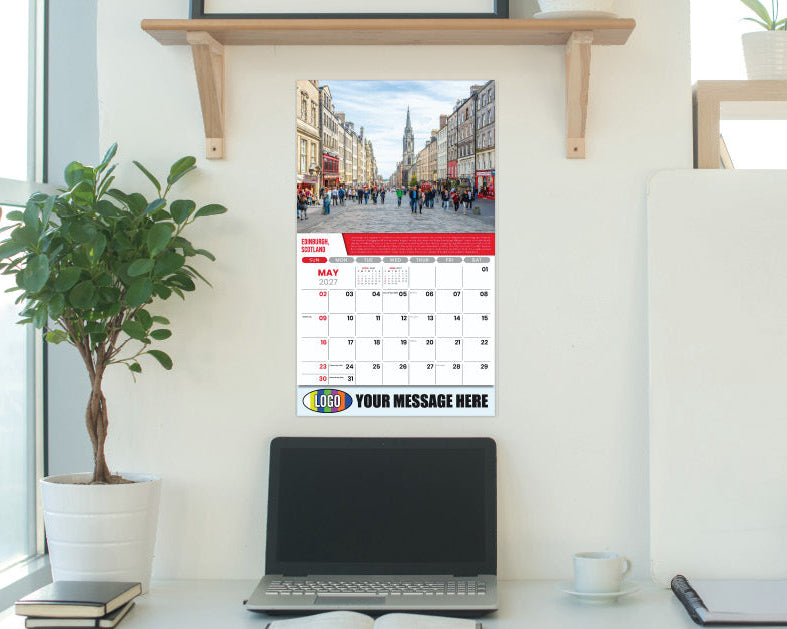 Branded Promotional Calendar on a wall in a modern office setting with a laptop and desk.